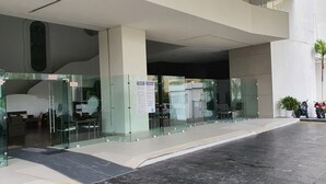 Une entrée moderne avec des portes en verre, un panneau indiquant « SORTIE » et une porte d’entrée motorisée.