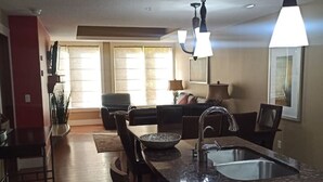 A modern kitchen with a granite countertop, stainless steel sink, and pendant lighting. - Stunning 2-BR Suite with Hot Tub & Mountain Views (Canmore)