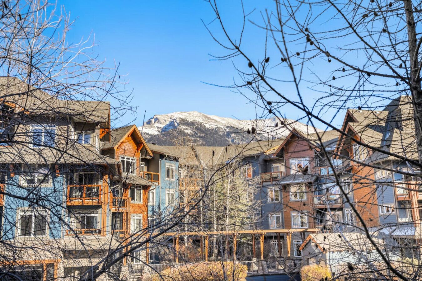 A row of multi-story buildings with a mountainous backdrop.