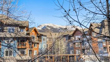 A row of multi-story buildings with a mountainous backdrop.