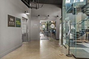 Ein Korridor mit Bar, Küchenbereich, Glastüren und einer Treppe.