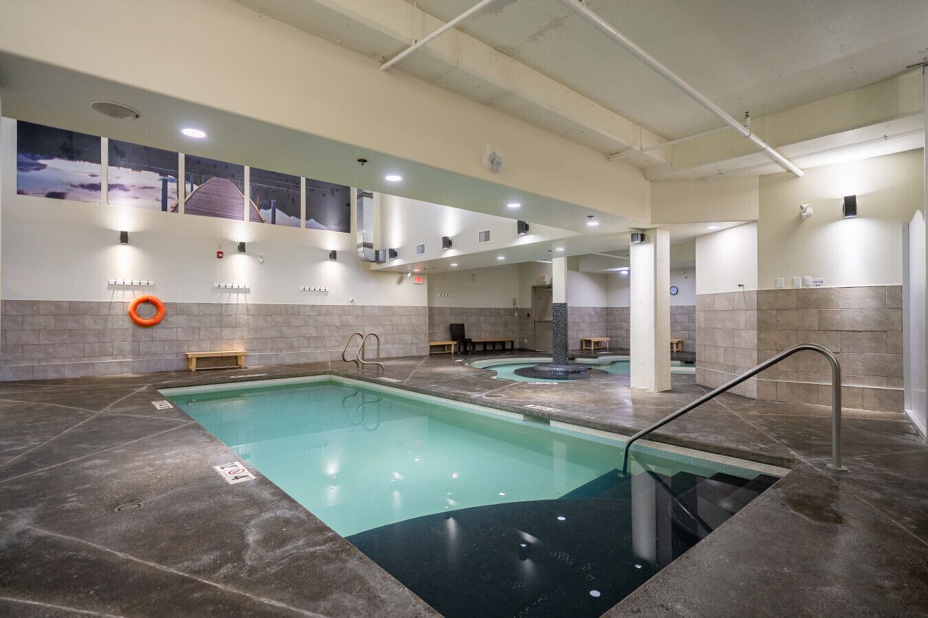 Une piscine dotée de plusieurs couloirs, de bancs et d’une bouée de sauvetage fixée au mur.
