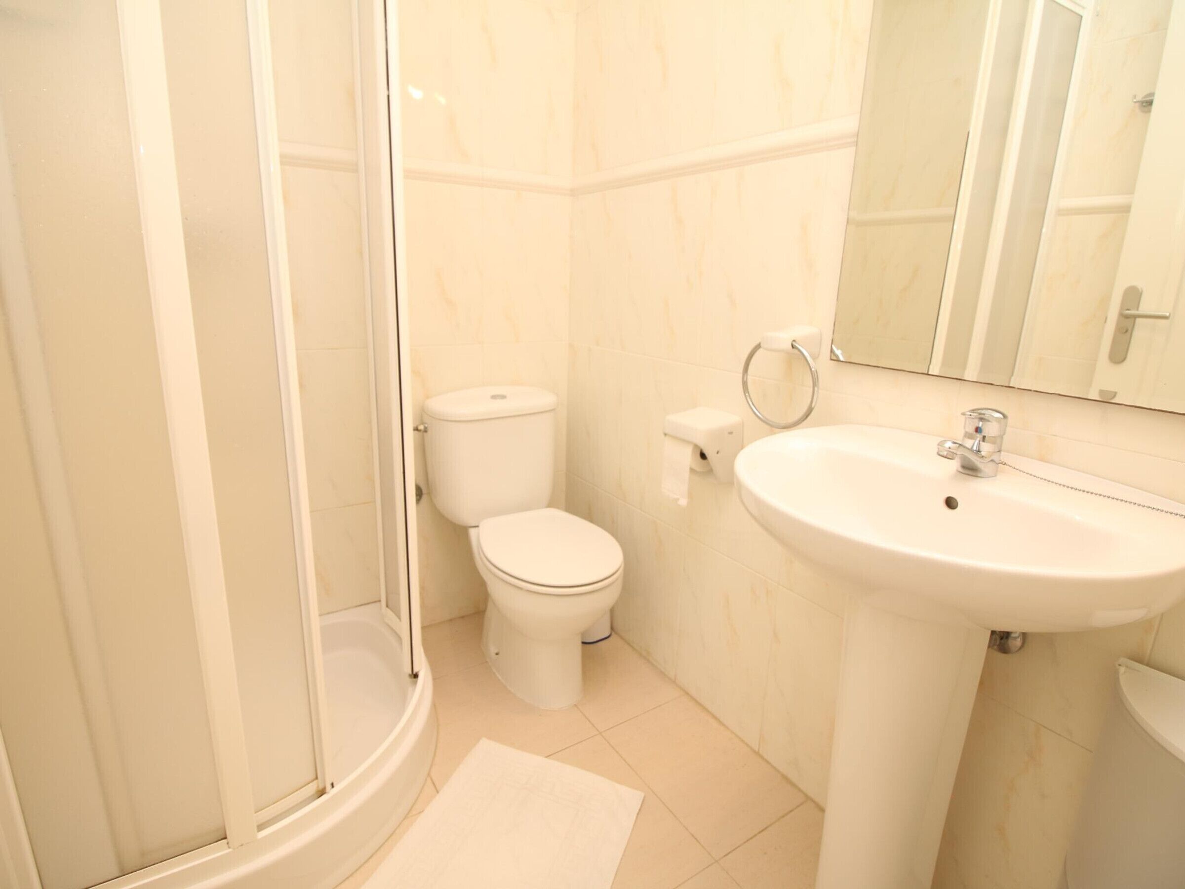 Een badkamer met toilet, wastafel en douche.