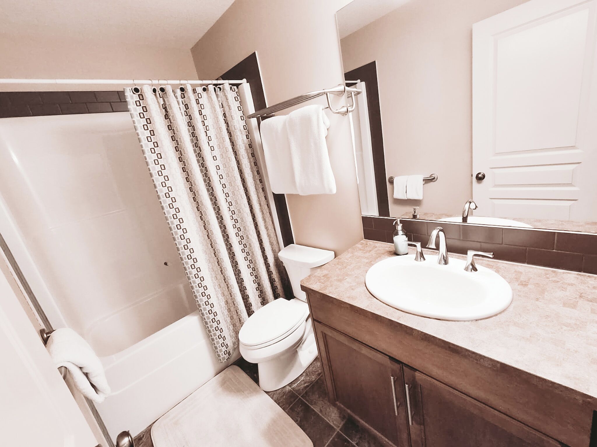 A bathroom with a bathtub, toilet, and sink.