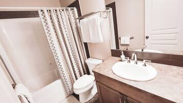 A bathroom with a bathtub, toilet, and sink.