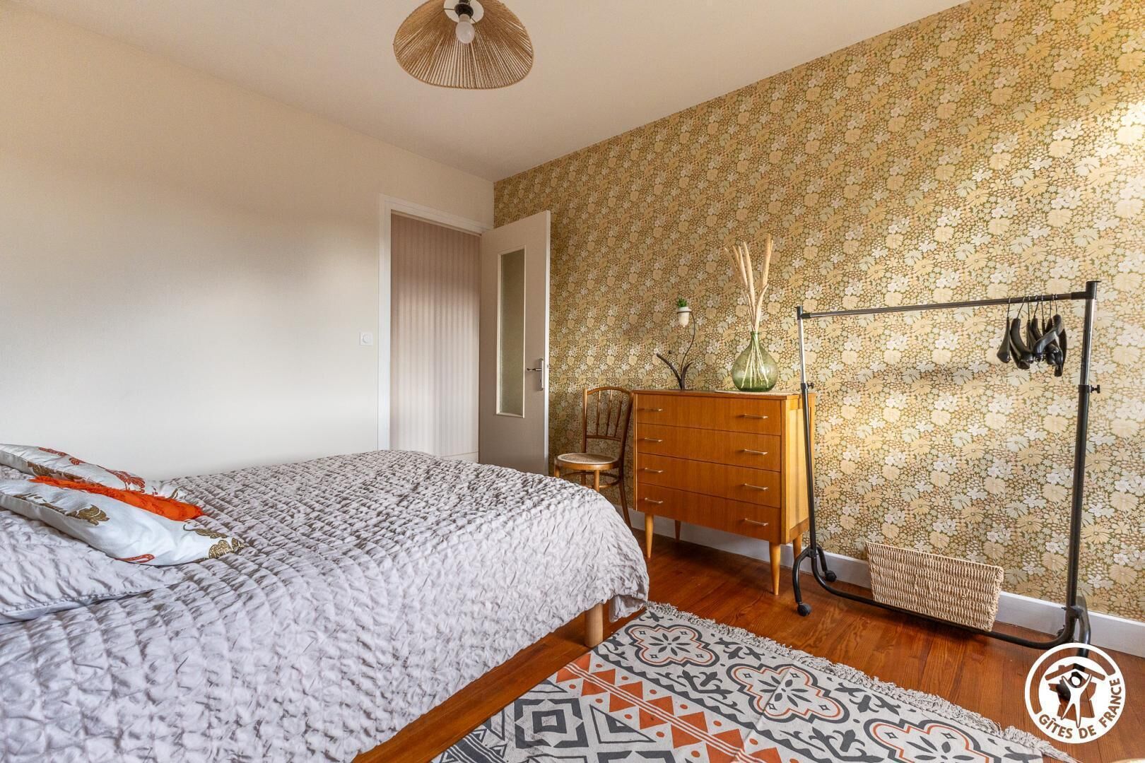 Ein Schlafzimmer mit einem Bett, einem Schminktisch und einem Schuhregal.