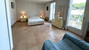 A bedroom with a bed, bedside tables, a dresser, a mirror, and a balcony with a view. - Apartment port view - 6 guests (Saint-Cyr-sur-Mer)