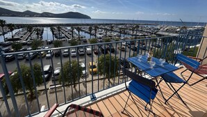 A balcony with a view of a marina, a table with glasses, and a bench. - Apartment port view - 6 guests (Saint-Cyr-sur-Mer)