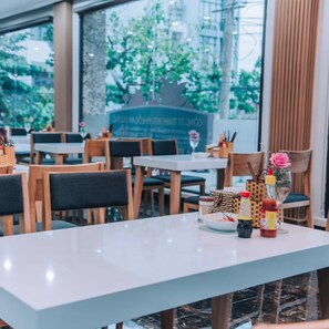 A restaurant interior with tables, chairs, and a menu board. - Shoho Hotel Nha Trang (Nha Trang)