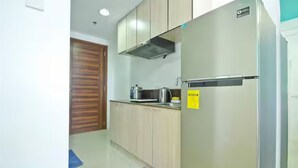 Una cocina con armarios de madera, un refrigerador de acero inoxidable y un tapete azul en el suelo.