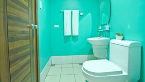 A bathroom with a toilet, sink, and mirror. - Bay Bridge View Studio 3 (Cebu City)