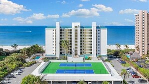 Et hotel med tennisbane, havudsigt og flere etager.