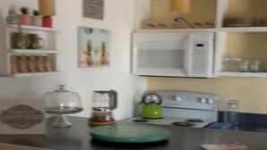 A kitchen with a stove, microwave, and various kitchen items on the counter. - Penguins on the Beach 2BR Steps to Beach & Downtown, pool,  Unit 7 (Cocoa Beach)