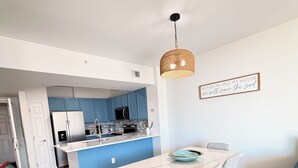 Una cucina moderna con mobili blu, un'isola bianca e una lampada a sospensione.