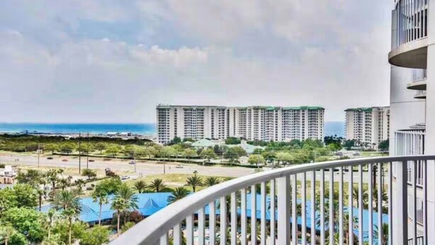 Zona residenziale con palazzi alti, cielo sereno e vista sull'oceano.