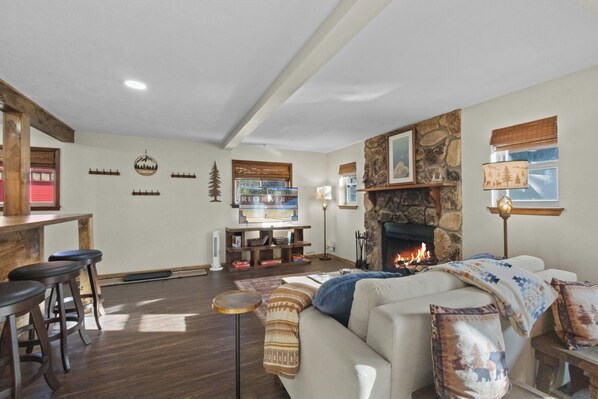 Un salón acogedor con chimenea, muebles de madera y una pared de acento de piedra.