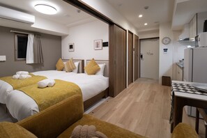 A hotel room with two beds, a small kitchenette, a dining area, and a bathroom. - The Peak Dotonbori (Osaka)