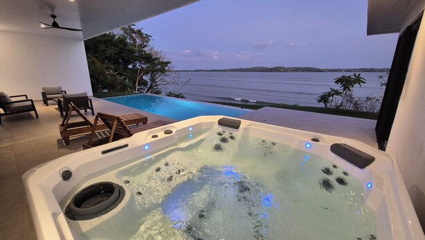 A hot tub with jets, a pool, and a view of the sea. - Stunning seaside villa with jacuzzi (Boca Chica)