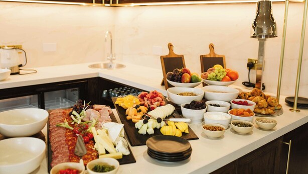A buffet with various food items and bowls arranged on a counter. - The Hillbrook Sherborne (Sherborne)