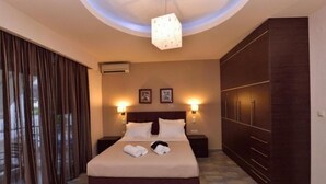 Ein Hotelzimmer mit einem großen Bett, zwei Nachttischen, einem Kleiderschrank und einer Deckenleuchte.