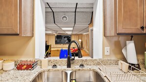 Una cocina con un lavamanos doble, armarios de madera y una encimera con escurreplatos.