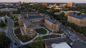 Un gran edificio de campus con varias secciones, rodeado de calles y otros edificios.