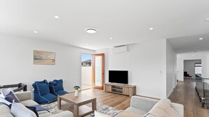 A modern living room with a sofa set, a coffee table, and a flat-screen TV. - Spacious Central 2 story Luxury with views (San Remo)