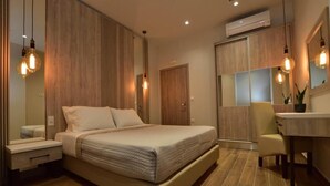 A modern bedroom with a large bed, bedside tables, a desk, and a chair. - Gonis Grand Luxury Suite (Kantanos-Selino)