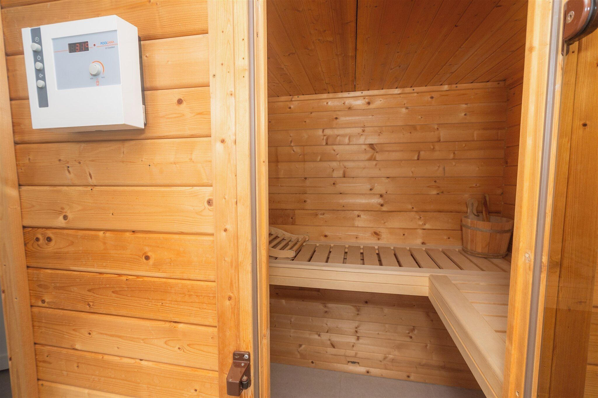 Eine Sauna mit Holzwänden und Bedienfeld.