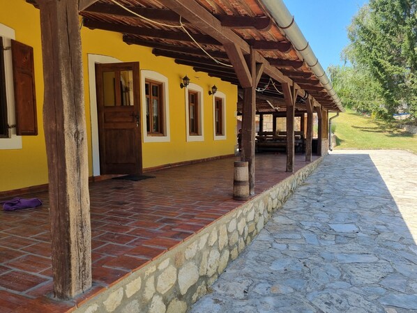 A building with a yellow facade, wooden beams, and a stone pathway.