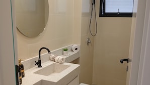 Un baño con lavamanos, inodoro y ducha.