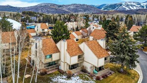 A residential area with modern houses, a road, and a mountainous backdrop. - Summit Chalet by Avantstay Mountain Condo + Hot Tub + Fireplace + Near Park City & Deer Valley (Park City)