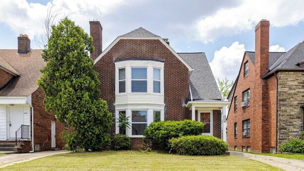 A two-story house with a bay window, brick exterior, and a well-maintained lawn. - 2-bedroom apartment in enjoyable University Heights (University Heights)