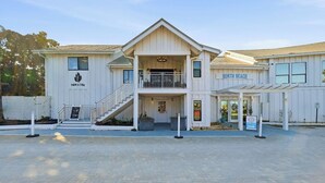 A two-story building with a covered entrance and a staircase leading to the upper level. - Luxury Townhome, close to the Bay, short drive to the Beach, Sleeps 10 (Santa Rosa Beach)