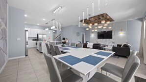 A modern kitchen with white cabinets, a built-in oven, and a stainless steel refrigerator. - Ultimate Disney Getaway | 12BR Bella Vida 30+ (Kissimmee)