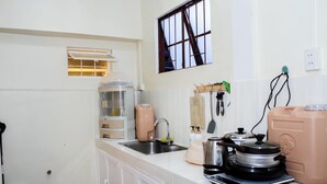 A kitchen with a sink, countertop, and various appliances including a coffee maker, kettle, and blender. - Cozy 2-bedroom house in amazing Legazpi City with AC, Fast Wifi & Kitchen (Legazpi City)