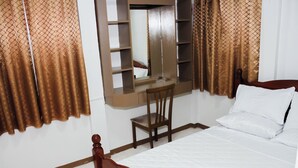 A bedroom with a bed, a wooden chair, a mirror, and a wardrobe. - Cozy 2-bedroom house in amazing Legazpi City with AC, Fast Wifi & Kitchen (Legazpi City)