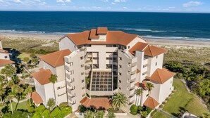 A multi-story hotel with a central courtyard, surrounded by a beach view. - Oceanfront Condo in Amelia Island Plantation with Pool (Fernandina Beach)