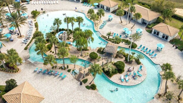 Vue aérienne d’un complexe hôtelier doté de plusieurs piscines, d’espaces de détente et de palmiers.