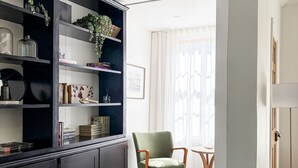 A modern living room with a dark wooden cabinet, a green armchair, and a gray sofa. - Kent House | Luxury heritage home, Prime location (Albany)