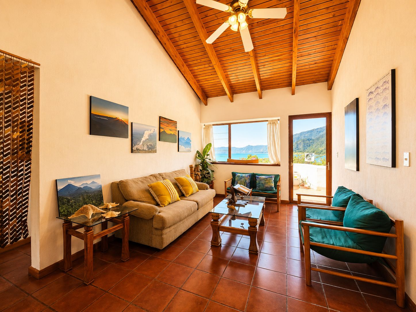 A spacious living room with a wooden ceiling, a sofa, a coffee table, and a view of the sea through large windows.