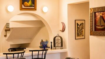 Un comedor con mesa de vidrio, sillas y un cuadro colgado en la pared.