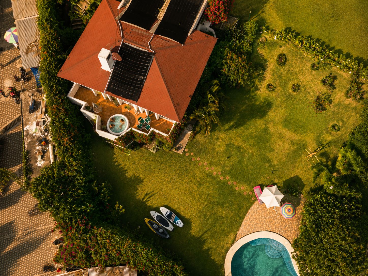 Eine Vogelperspektive eines Hauses mit Swimmingpool, Whirlpool und Garten.