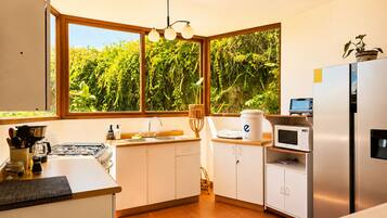 Una cocina moderna con un ventanal grande, un fregadero, una estufa y un refrigerador.