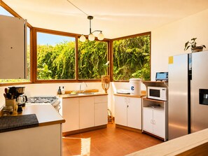 Eine moderne Küche mit einem großen Fenster, einer Spüle, einem Herd und einem Kühlschrank.