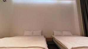 Een hotelkamer met twee eenpersoonsbedden, een nachtkastje en een stopcontact.