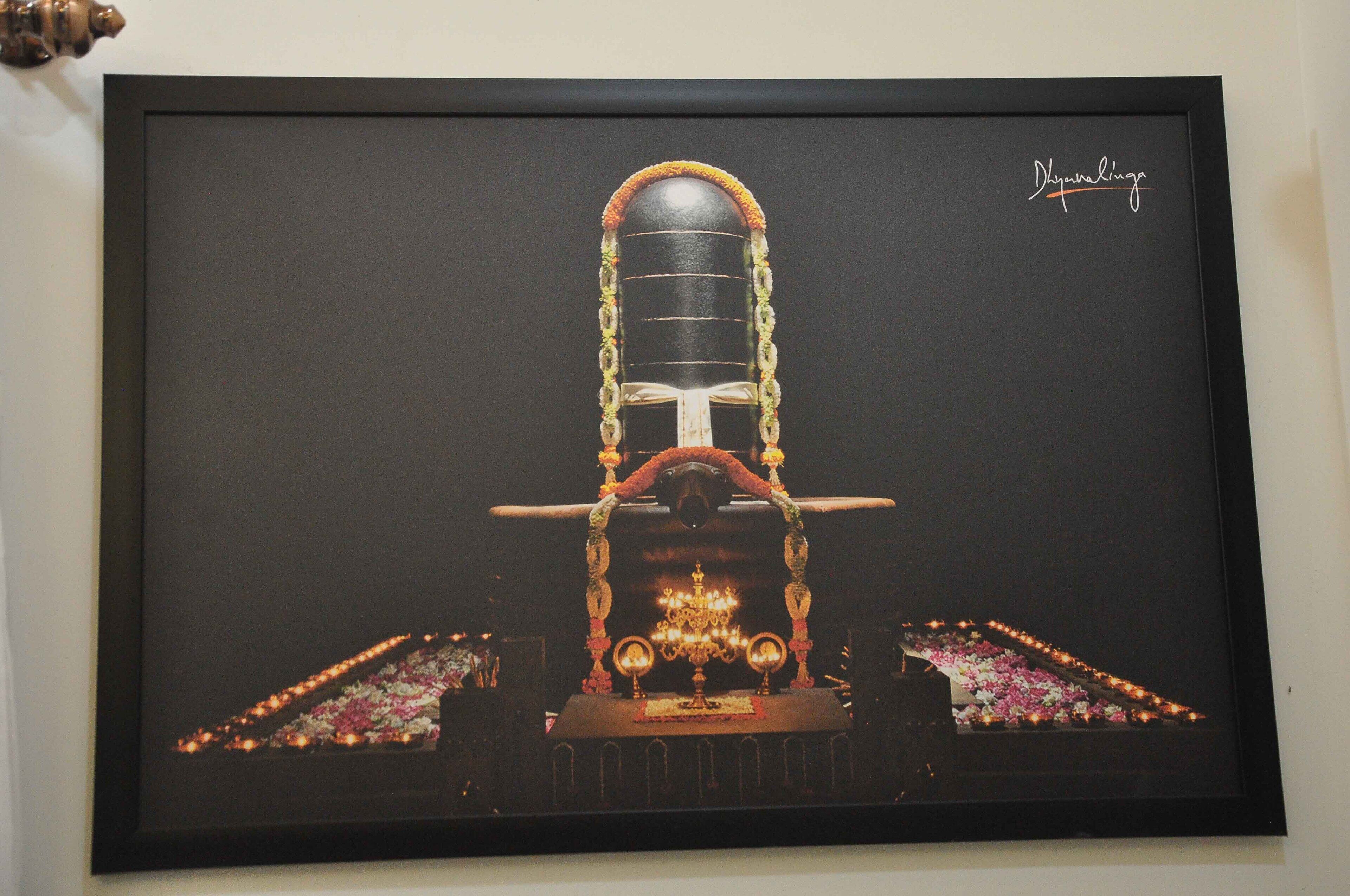 A framed artwork of a traditional structure with a central dome, flanked by two candlelit pathways, and a signature in the top right corner.
