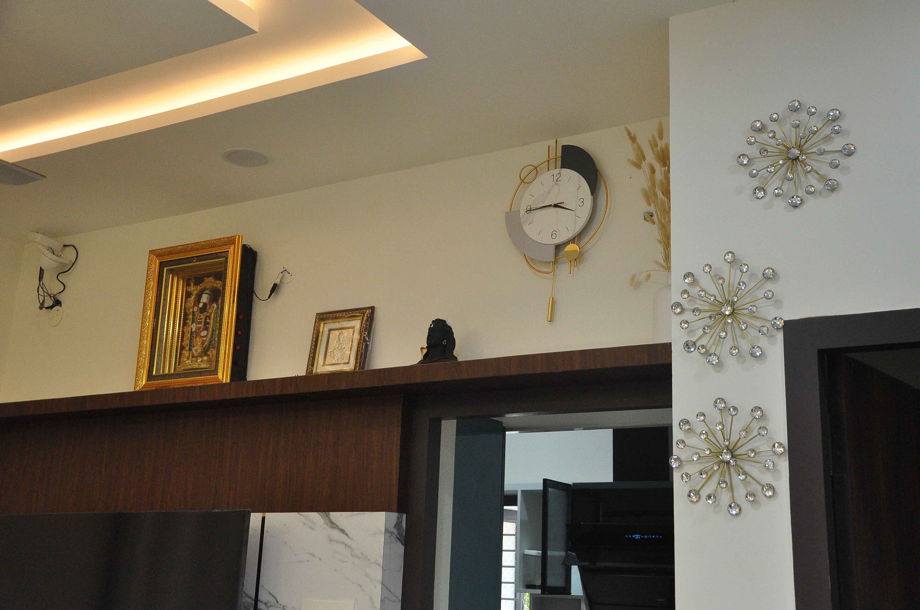Une pièce avec un plafond en bois, un mur en marbre et une porte. Il y a deux horloges murales et un tableau encadré accroché au mur.
