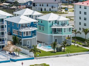 Ein mehrstöckiges Hotel mit Balkonen, einem Swimmingpool und Blick auf den Strand.