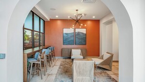 Un intérieur moderne avec un bar, des sièges et des œuvres d’art accrochées au mur.